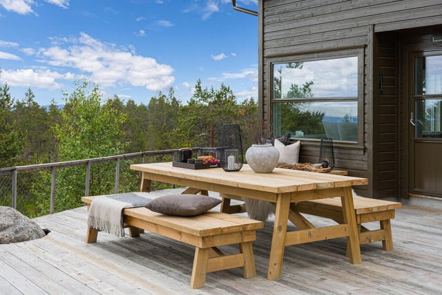 En romslig og innbydende terrasse med god plass til spisegruppe, for lange måltider og hyggelige sammenkomster under åpen himmel.