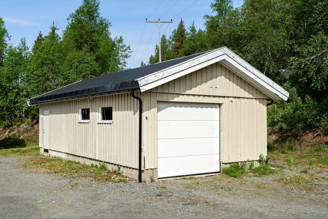 Garasjen er bygget med en støpt betongsåle på grunn og grunnmurer av betong. Ytterveggene er av bindingsverk i tre med stående kledning, og taket er en saltakskonstruksjon tekket med profilerte stålplater.