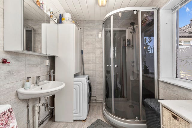 Fra entreen er det direkte adkomst til boligens første baderom. Badet har flislagt gulv med varmekabler.