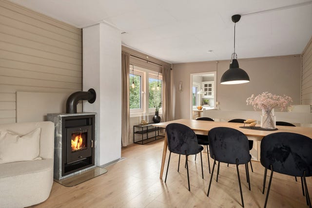 En moderne, integrert ovn er plassert rett ved spiseplassen, noe som gir både god varme og en koselig atmosfære.