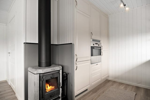 Flammer i ovn er redigert inn i foto. Feietjenesten har opplyst at pipen aldri har vært feiet, og at det på generelt grunnlag frarådes fyring før skosteinen er feiet og kontrollert (manglet tilkomst i 2025 da dette skulle utføres).