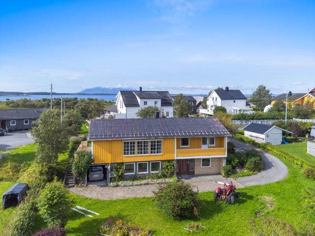 Huset er oppført med garasje i sokkeletasjen og har belegningsstein foran inngangen.