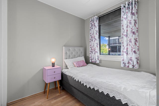 Lyst og innbydende soverom med god plass til seng og skap.