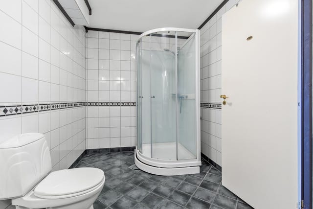 Klosett, dusjkabinett og servant med underskap.