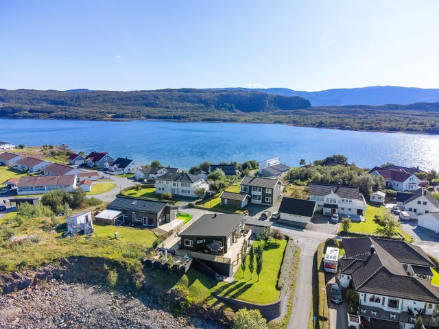 Eiendommen har en høy beliggenhet og er opparbeidet med plen, hekk og beplantning.
