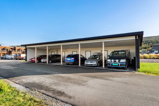 Fast parkeringsplass i carport i rekke. I bakkant er det en sportsbod på ca. 5 m2.