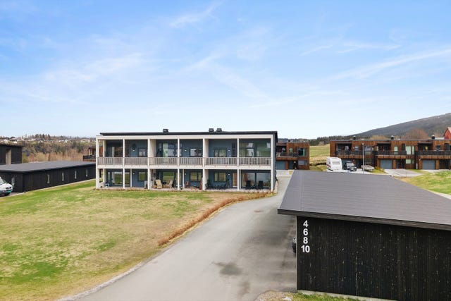 Eiendommen har en tilnærmet flat og felles hage, pent opparbeidet og vedlikeholdt av en robotklipper - en praktisk og tidsbesparende løsning som sikrer at uteområdet alltid ser velstelt ut.
