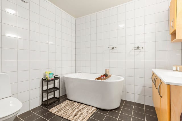 Badet i 1. etasje er innredet med badekar, romslig baderomsinnredning og toalett.