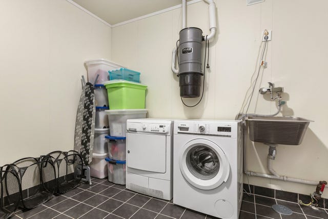 Romslig vaskerom med opplegg for vaskemaskin, utslagsvask og sentralstøvsuger. Plass til både tørketrommel og oppbevaring.