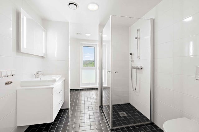 Badet er stort og praktisk utformet med to soner en for bad og en for vaskerom. Veggene og gulvet er flislagt, og gulvet har varmekabler for en lun start og slutt på dagen.