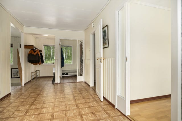 Velkommen inn i en romslig og praktisk entré med egen innhuk for oppheng av klær og sko. Entreen gir adkomst til stue og kjøkken i den ene retningen, og soveromsfløy og bad i den andre.