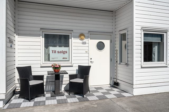 Ved inngangsdøren til leiligheten er en takoverbygget innhuk med plass til en liten sittegruppe.