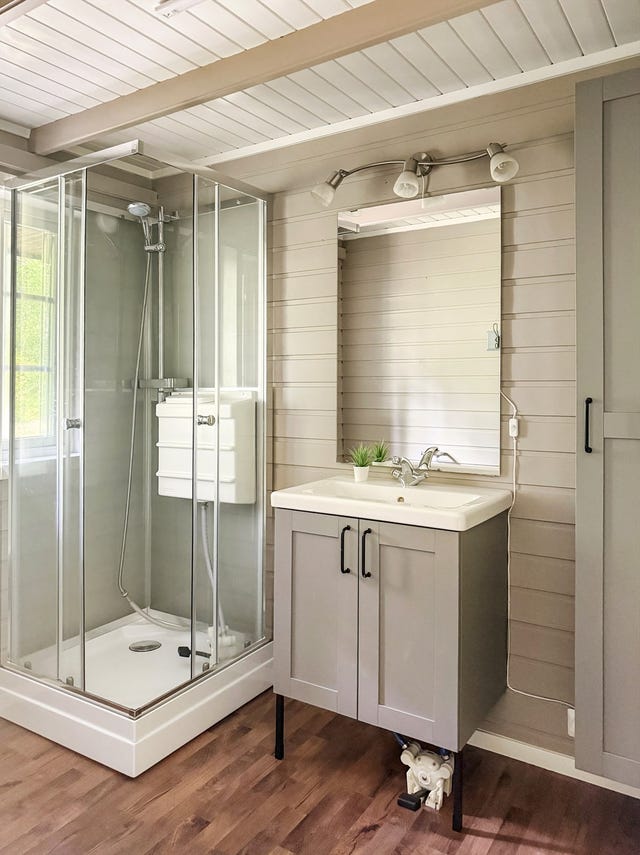 Badet er innredet i moderne, harmoniske fargetoner og er utstyrt med et praktisk dusjkabinett og en stilren servantinnredning. Praktisk pumpeløsning for dusj og vask.