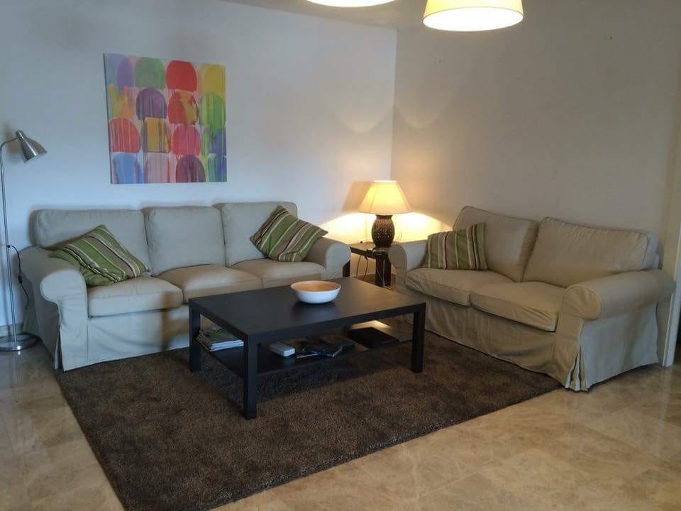 Romslig stue med to sofagrupper og spisestue. TV i den innerste delen. Galleribilde