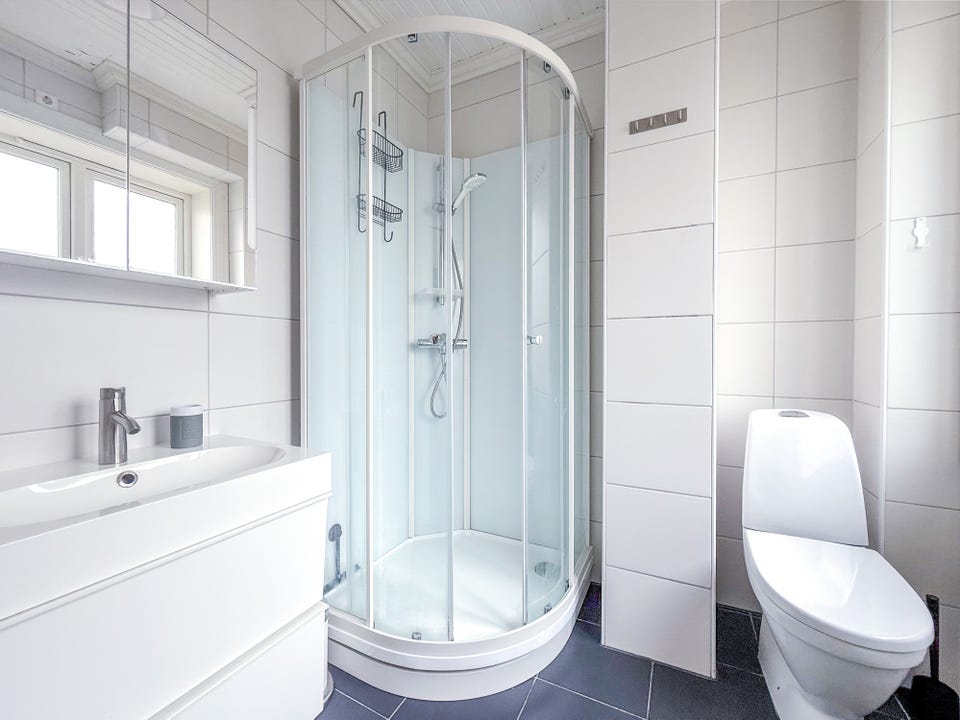 Tiled bathroom with shower cubicle.