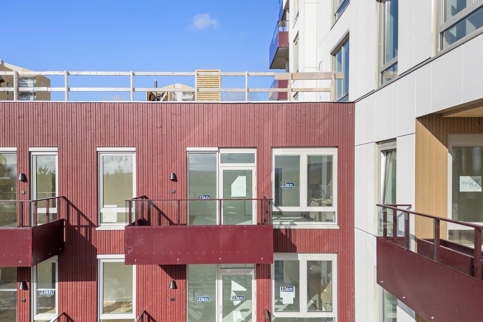 Fasaden i lamellbygget, med felles takterrasse øverst.