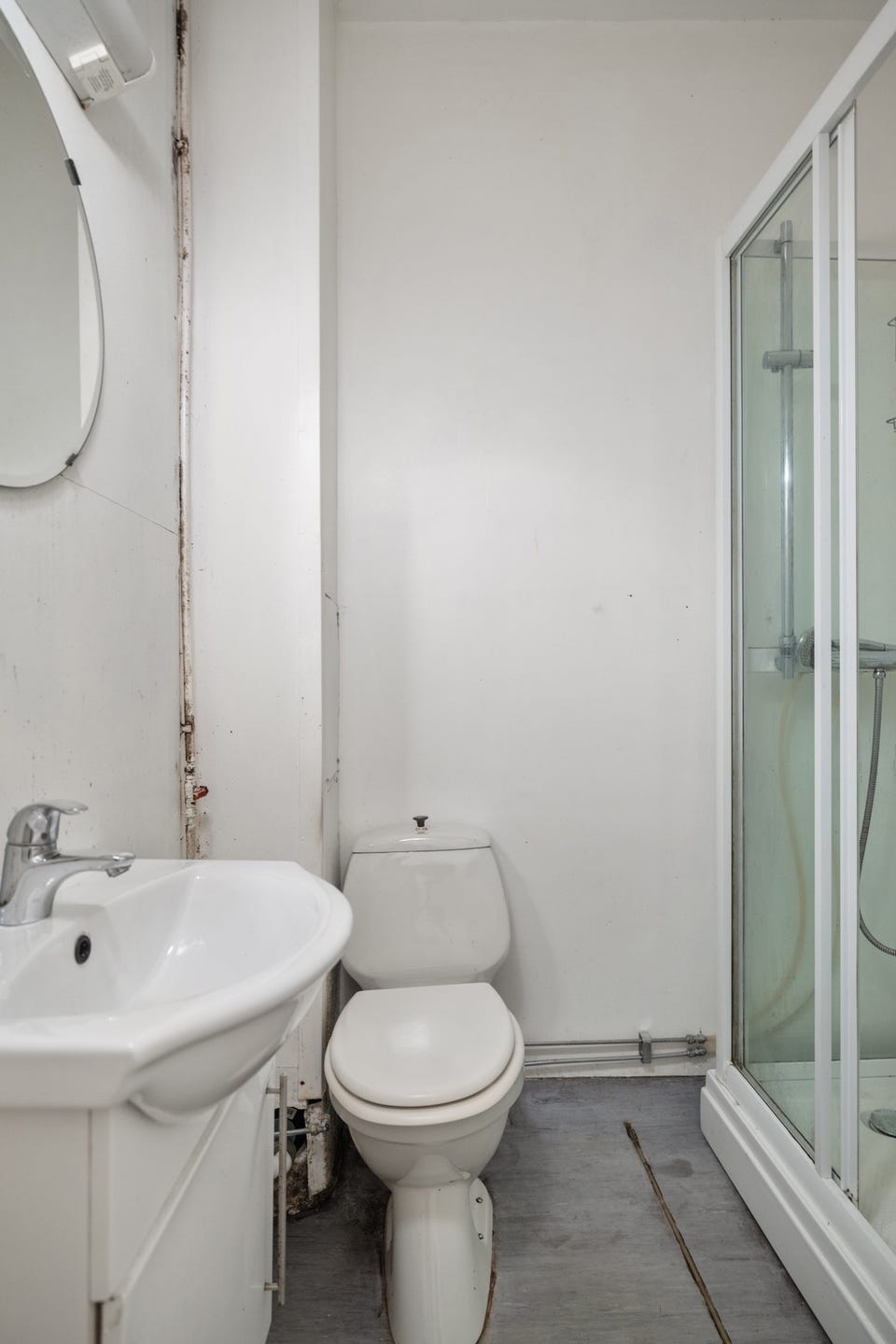Bad med servant, toalett og dusjkabinett. Badet har TG3; tilstandsrapporten anbefaler full rehabilitering før ordinær bruk.