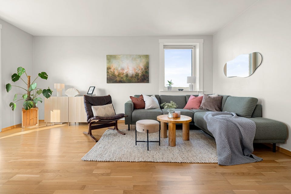 God plass til sofagruppe, spisebord i tilknytning til kjøkken og TV med tilhørende møblement.