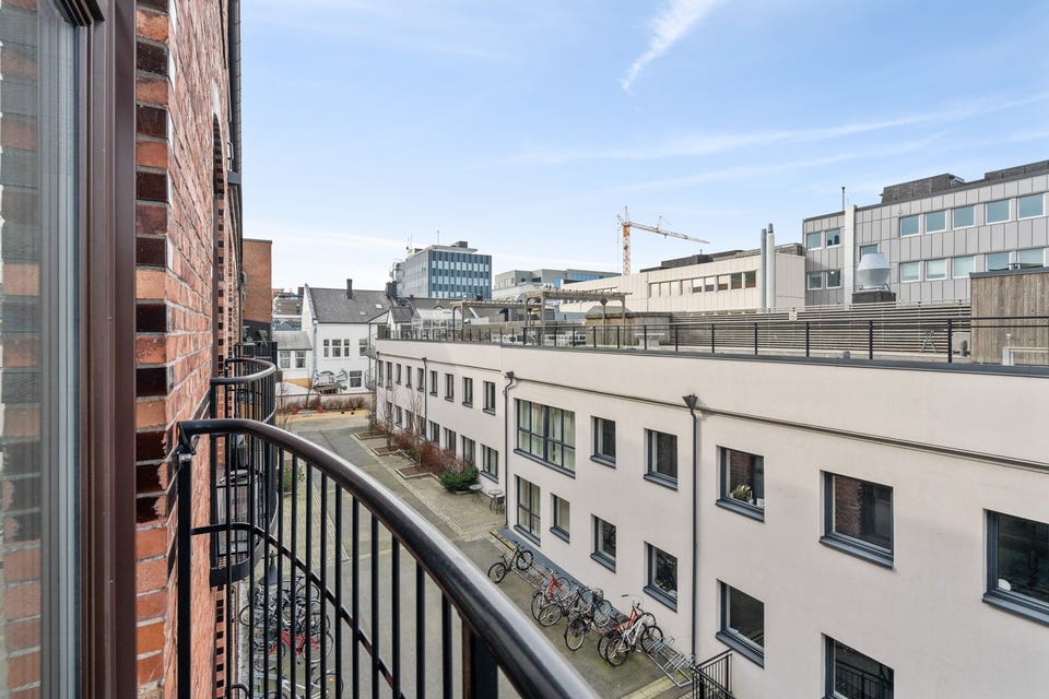 Utsikt mot vest over rolig bakgård uten biltrafikk.