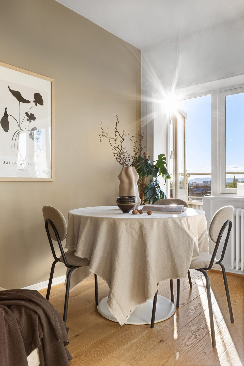 God plass til spisegruppe mot vindusflatene og balkongen i suten.