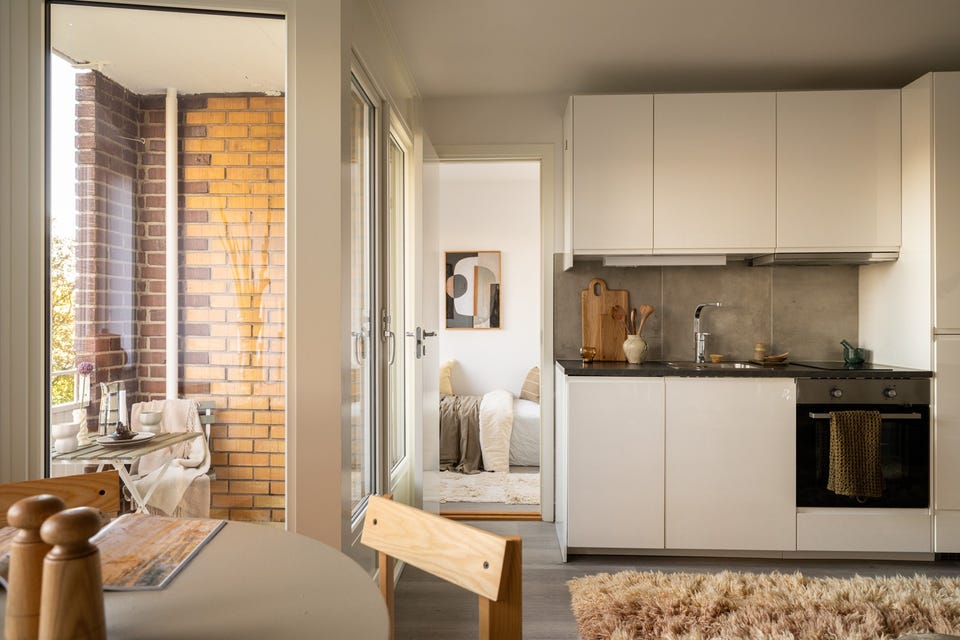 Lyst og moderne Ikea-kjøkken fra 2018. Innredningen har hvite glatte fronter og laminert benkeplate med nedfelt oppvaskkum. Både fint og praktisk med flotte fliser i benkeryggen og belysning under overskap.