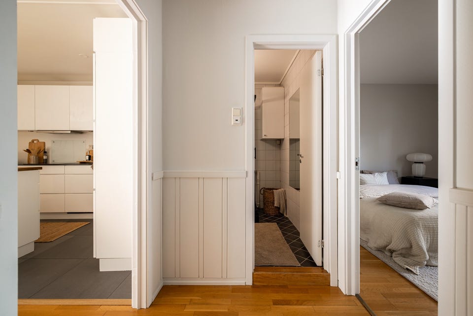Entréen har parkett på gulv og lysmalte overflater med brystningspanel.
