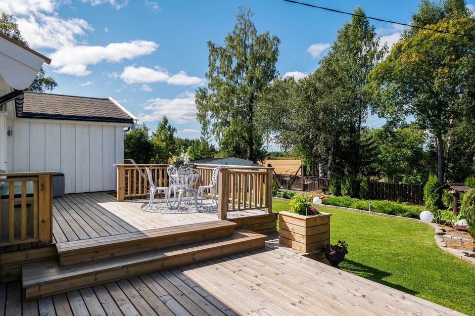 Terrassen har terrassebord og rekkverk av tre.