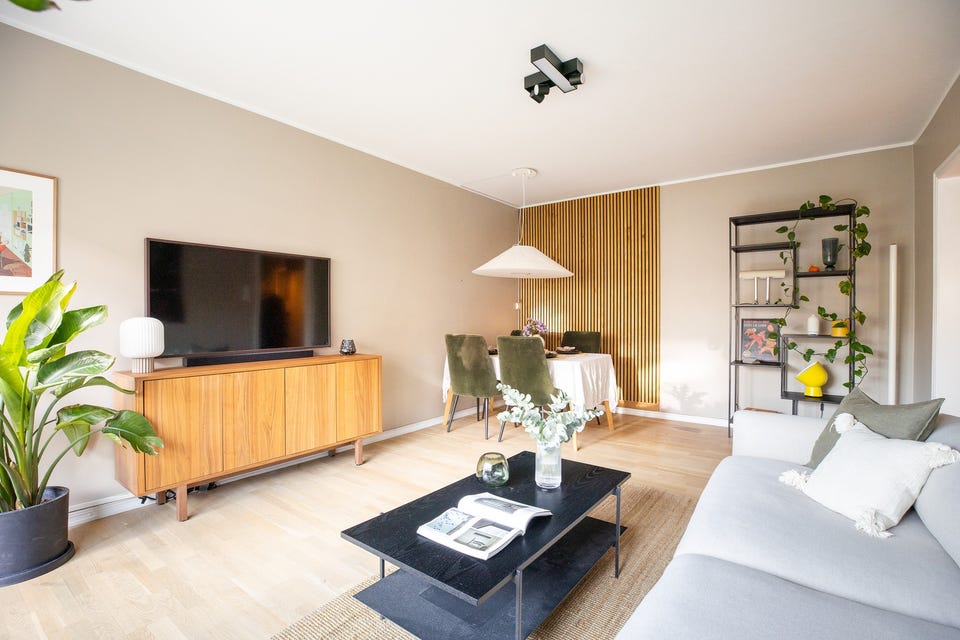 Stuen er romslig med god plass til stor sofagruppe med salongbord, mediemøblement med tv og et spisebord.
