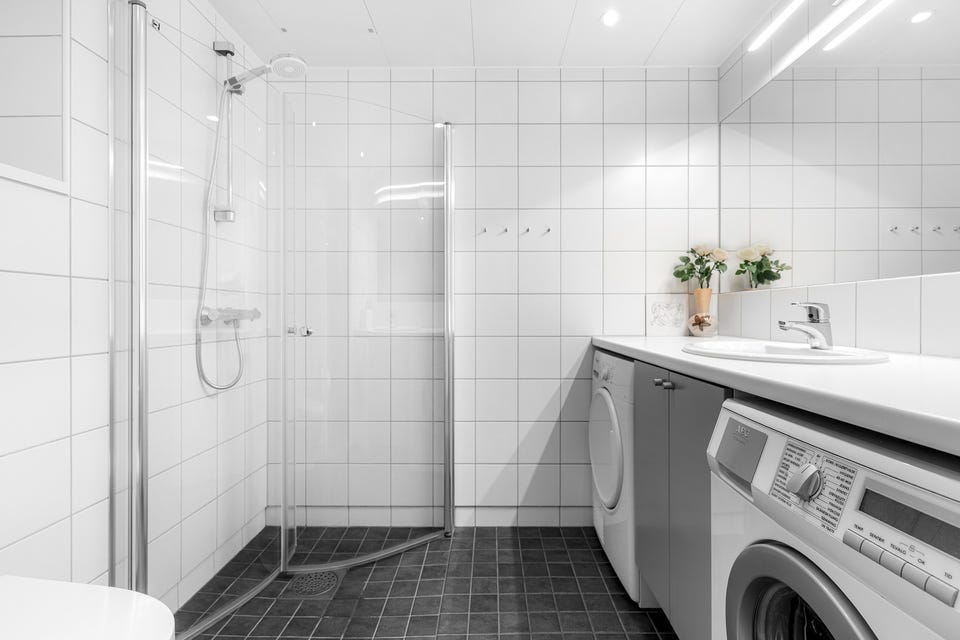 Lyst og moderne baderom fra byggeåret 2008. Baderommet har mørke fliser på gulv med gulvvarme, hvite fliser på veggene, downlights i himlingen og mekanisk avtrekksvifte.