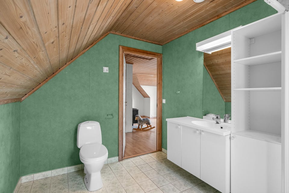 Badet i 2. etasje er fra byggeår. Flislagt gulv med gulvvarme og flislagte vegger.