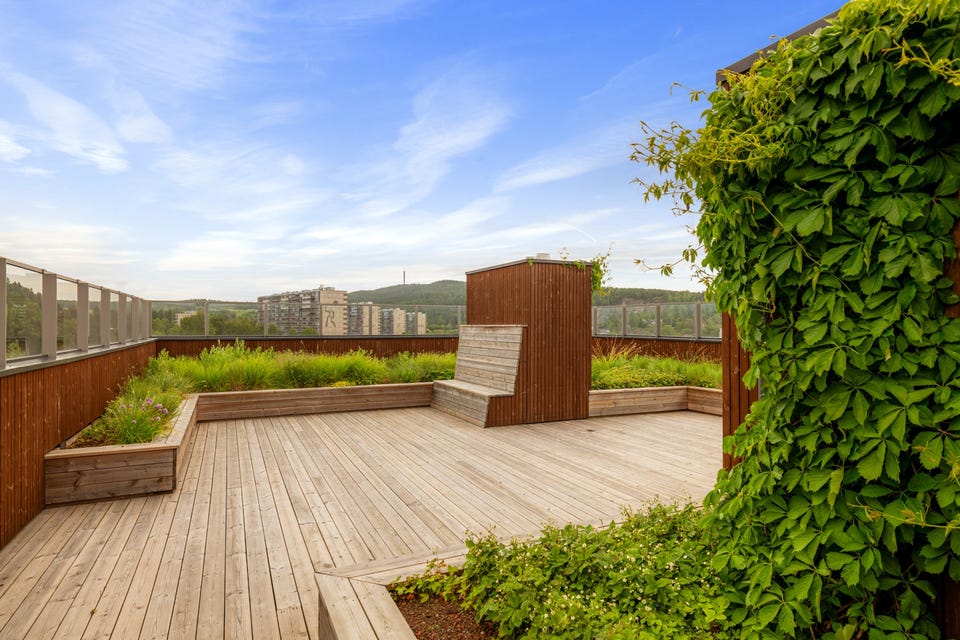 Takterrassen er meget pent opparbeidet med sitteplasser og beplantning.