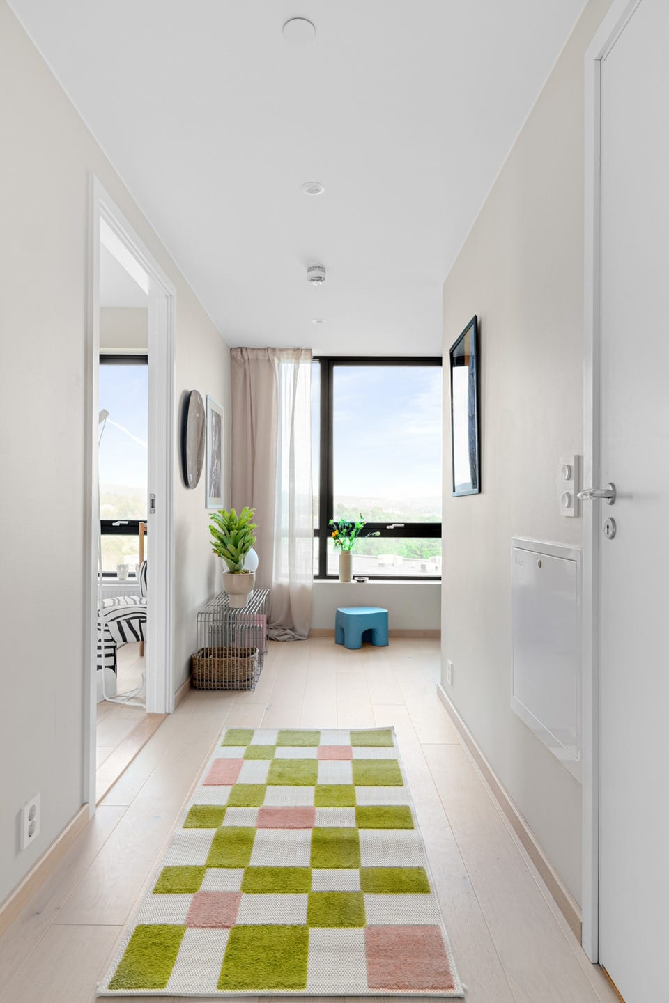Lys og innbydende gang med stort vindu og downlights i himlingen.