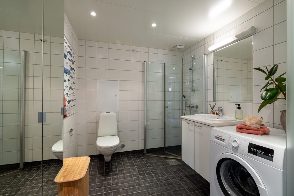 Pent baderom fra byggeår med fliser på overflater, samt gulvvarme.