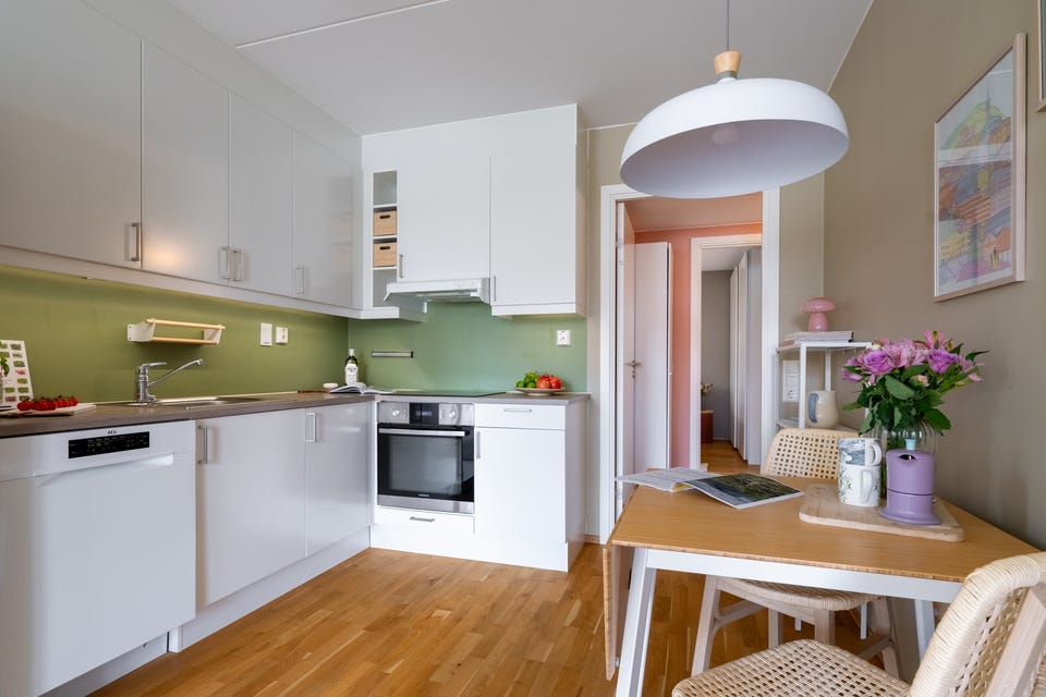 Kjøkkeninnredning med lyse glatte fronter og benkeplate med laminert overflate.