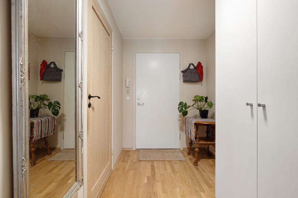 Entréen har parkett på gulv, glatte malte overflater og skjult elektrisk anlegg.