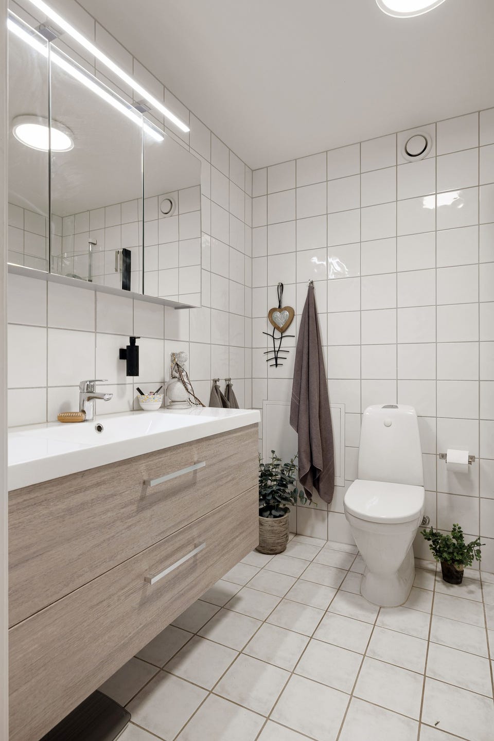 Baderommet er også utstyrt med gulvstående toalett og dusjhjørne med innfellbare glassdører.