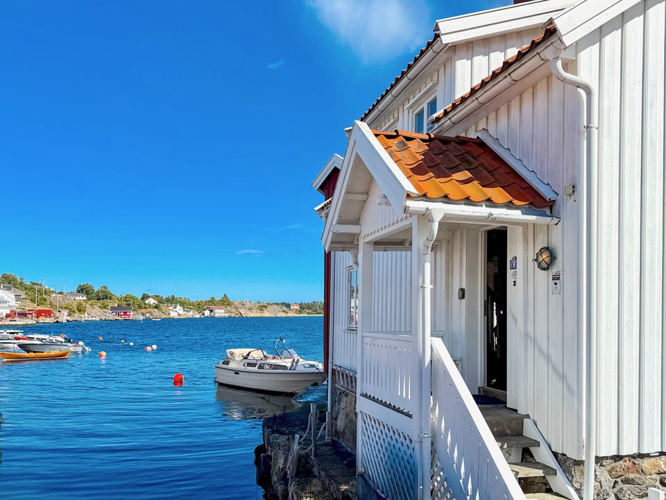 Overbygd inngangsparti med sjøen og båtlivet rett utenfor døren