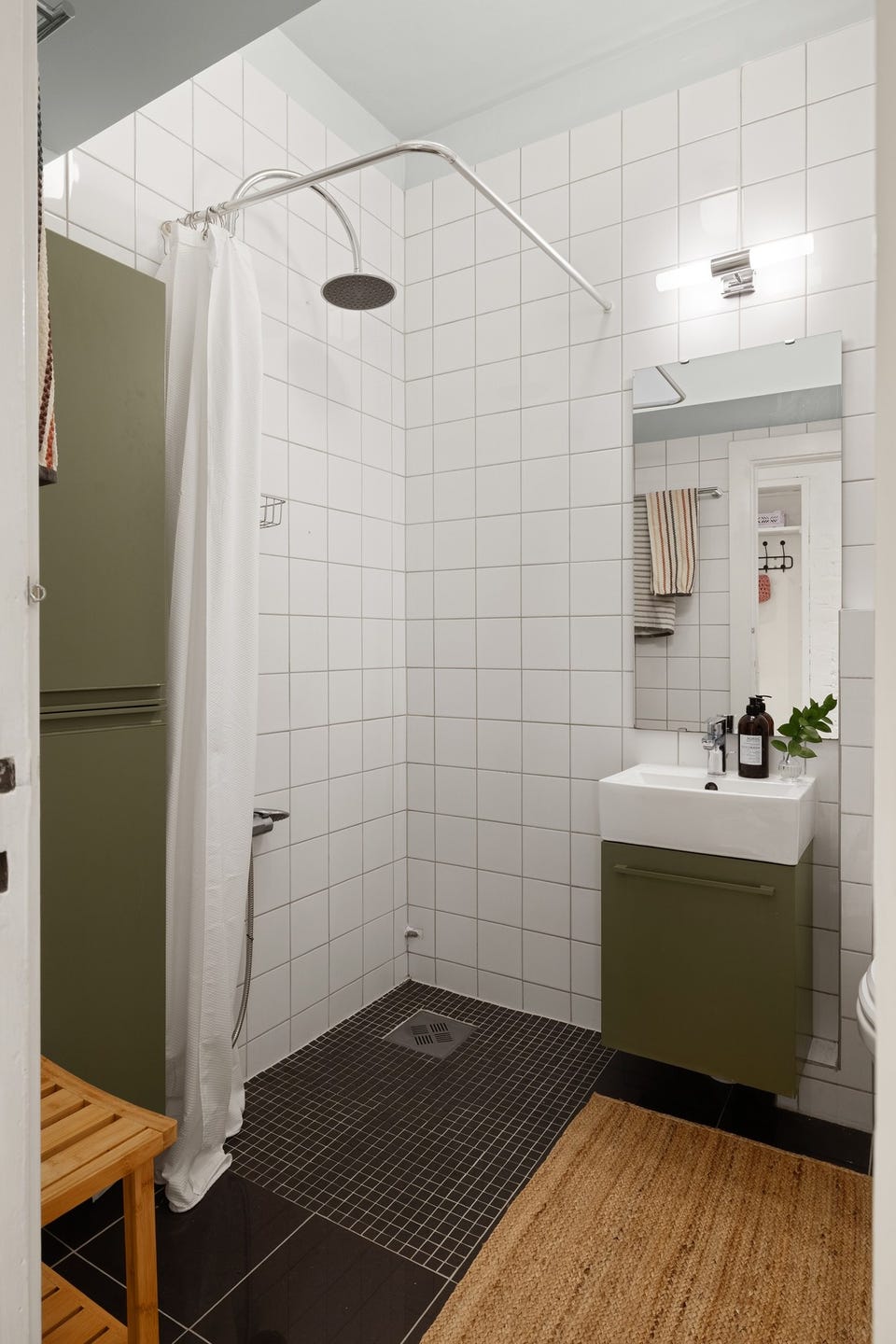 Badet har dusjnisje og varmekabler på gulvet. Vaskemaskin er plassert i separat vaskerom.