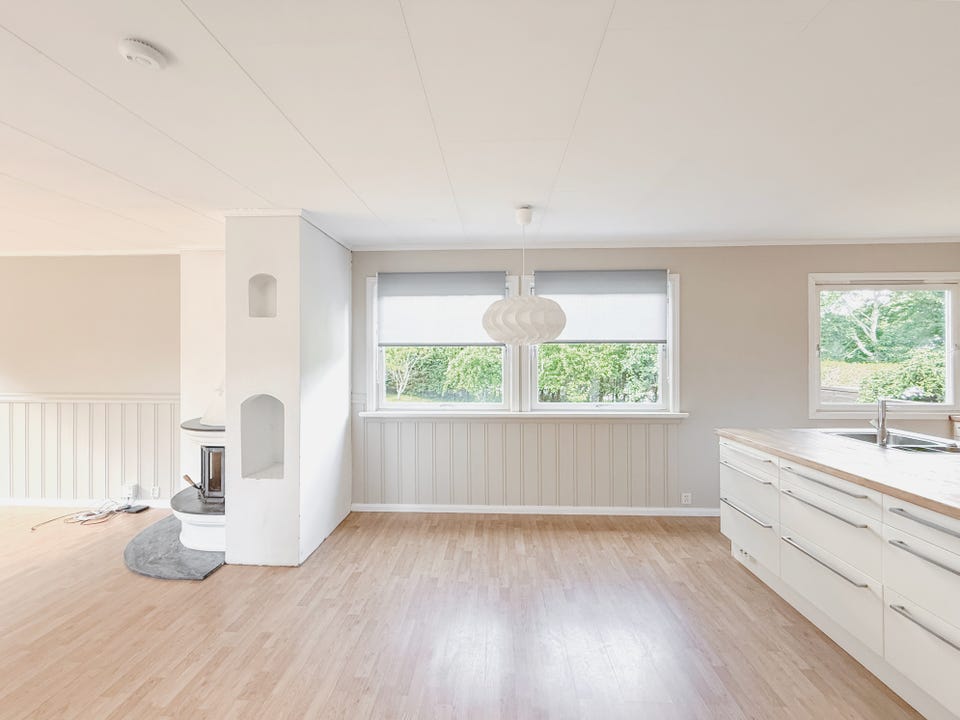Lys stue med peis og plass til både sofagruppe og spisebord