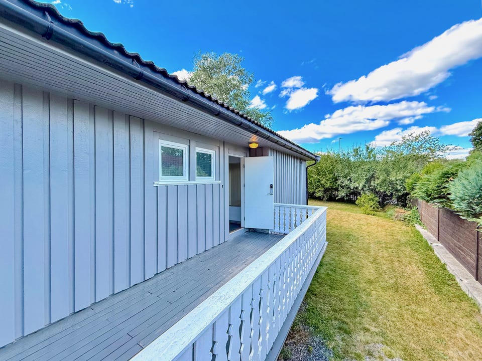 Overbygd terrasse langs boligens side med videre adkomst til hagen