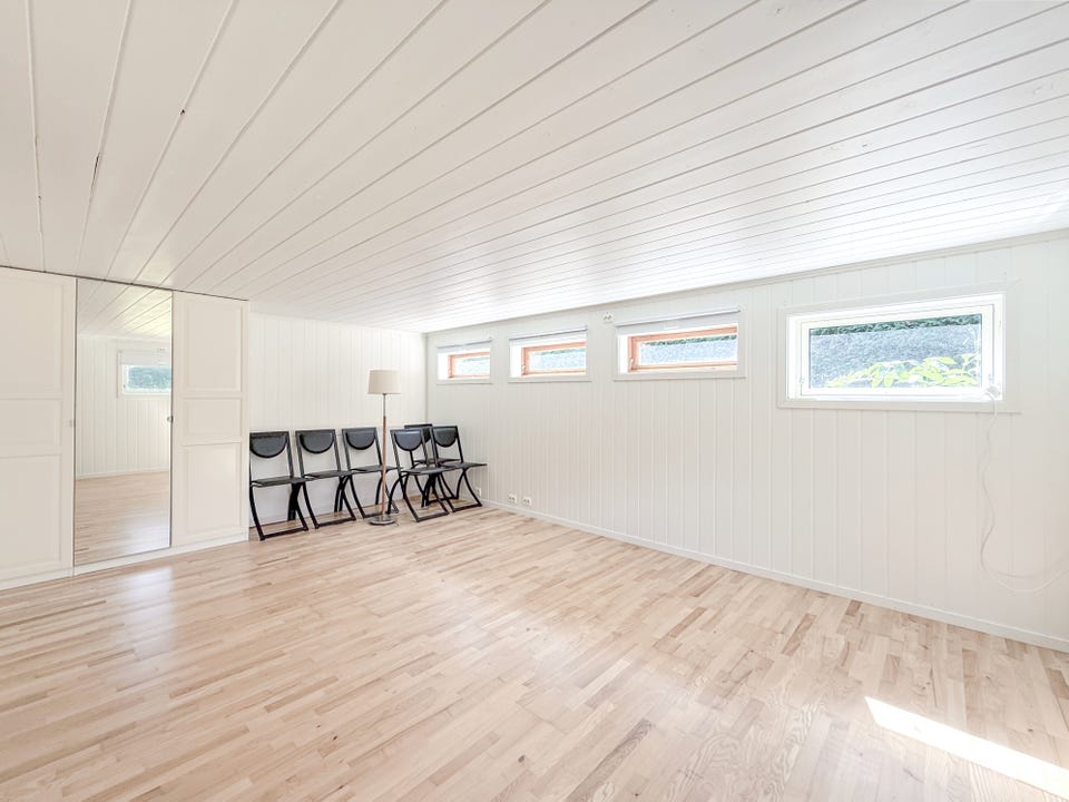 Stor og lyst soverom med flere vinduer og god plass til møblering