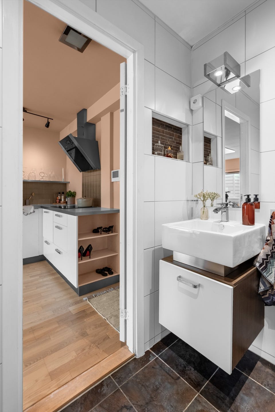 Badet består av veggmontert baderomsinnredning med ovenpåliggende servant med ett-greps armatur. Vegghenhgt speil med belysning og en praktisk nisje ved siden av speil for oppbevaring.