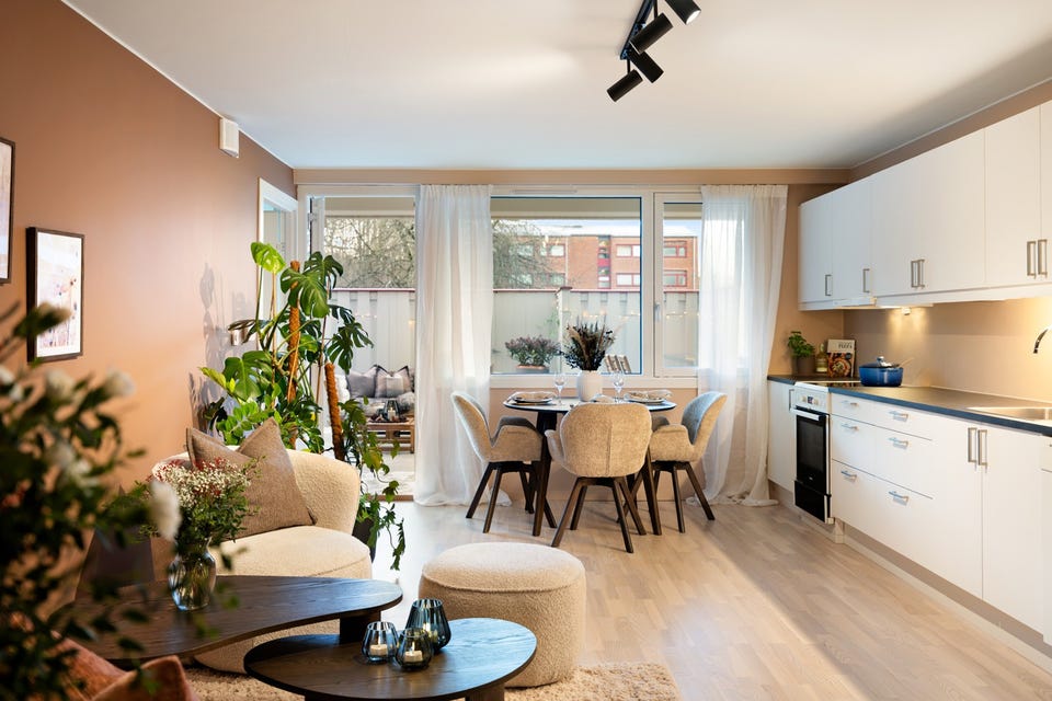 Stuen har store vindusflater og utgang til en terrasse, som gir godt med naturlig lysinnslipp og en luftig romfølelse.