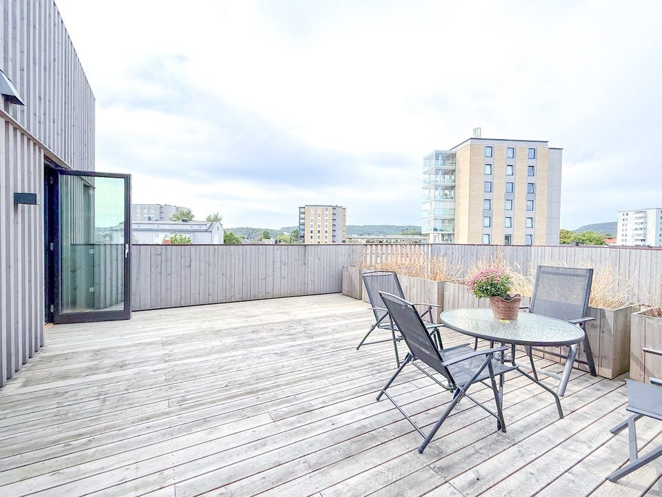 Romslig terrasse med god plass til bord, stoler og annen utemøblering.