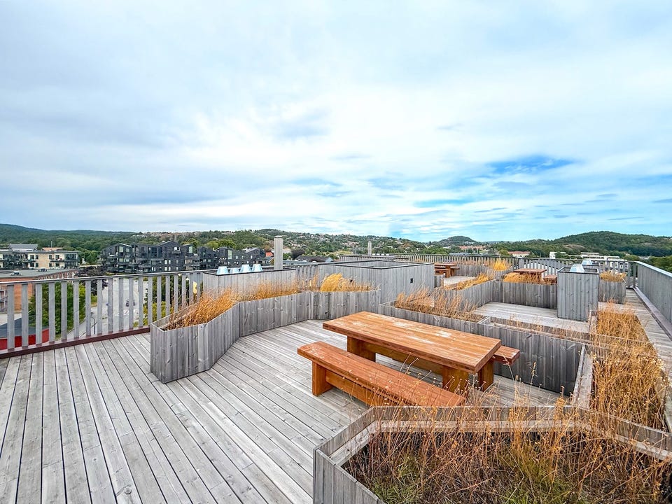 Felles takterrasse med sitteplasser og utsikt.