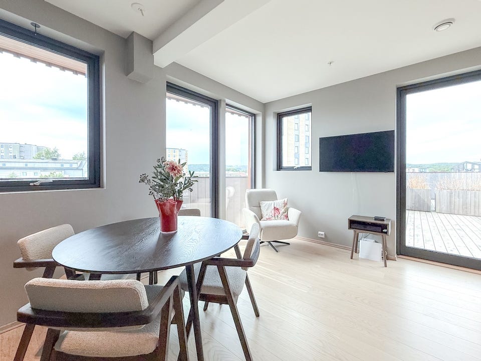 Stue og spiseplass med vinduer i flere retninger.