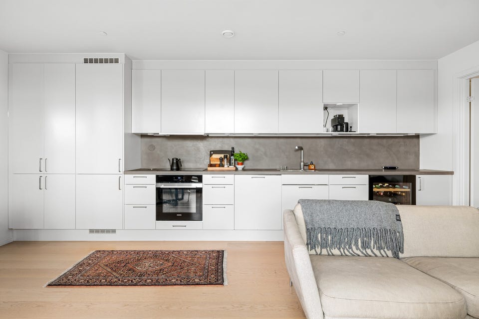 Moderne kjøkken som ligger i en sosial og åpen løsning mot stuen.