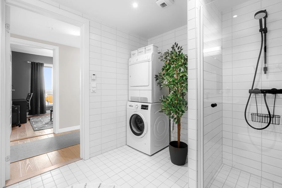 Badet inneholder vegghengt servantskap, speil over servant, dusjnisje med glassdør og innebygget sisterne med vegghengt klosett.