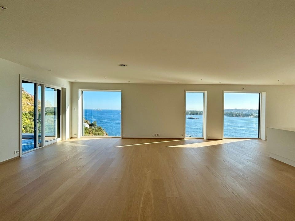 Open living room with large windows. Plenty of natural light from both sides. External sun shading is fitted to the windows facing the view