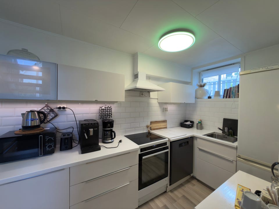 Dekorativ lampe som kan endre farge. Rikelig med skap og benkeplass til alt som følger med på kjøkken.